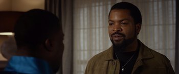 Movie still from “Ride Along 2” (2016), directed by Tim Story – A man with a beard is talking to another man in a room; Close Up shot, Over the shoulder angle