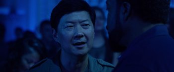 Movie still from “Ride Along 2” (2016), directed by Tim Story – An asian man in a dark room with blue lighting; Close Up shot, Over the shoulder angle