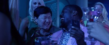 Movie still from “Ride Along 2” (2016), directed by Tim Story – A man and a woman laughing together at a party; Close Up shot, Over the shoulder angle