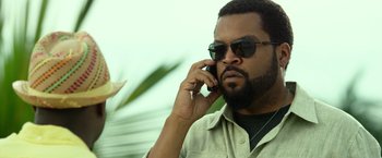 Movie still from “Ride Along 2” (2016), directed by Tim Story – A person talking on a cell phone; Close Up shot, Low angle
