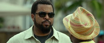 Movie still from “Ride Along 2” (2016), directed by Tim Story – A person wearing sunglasses and a hat; Close Up shot, Over the shoulder angle