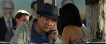 Movie still from “Ride Along 2” (2016), directed by Tim Story – A man wearing a hat talking on a cell phone; Close Up shot, Over the shoulder angle