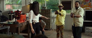 Movie still from “Ride Along 2” (2016), directed by Tim Story – A man and a woman are standing in front of a man; Medium shot, Over the shoulder angle