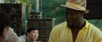 Movie still from “Ride Along 2” (2016), directed by Tim Story – A man wearing a hat and a yellow shirt; Close Up shot, Over the shoulder angle