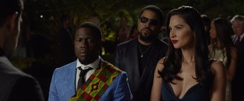 Movie still from “Ride Along 2” (2016), directed by Tim Story – A group of people standing next to each other in a room; Medium shot, Over the shoulder angle