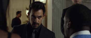 Movie still from “Ride Along 2” (2016), directed by Tim Story – A man in a black suit and a black neck tie; Close Up shot, Over the shoulder angle