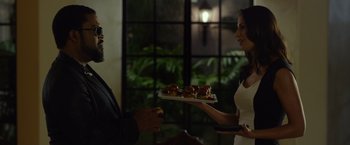 Movie still from “Ride Along 2” (2016), directed by Tim Story – A man and a woman holding a tray of doughnuts; Medium shot, Over the shoulder angle