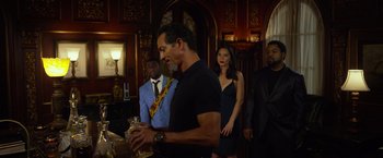 Movie still from “Ride Along 2” (2016), directed by Tim Story – A group of men and women standing in a room; Medium shot, Over the shoulder angle