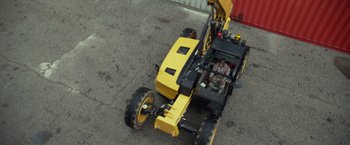 Movie still from “Ride Along 2” (2016), directed by Tim Story – An aerial view of a construction vehicle with a man sitting in the back; Extreme Wide shot, High angle
