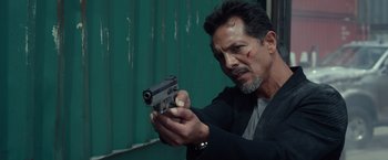 Movie still from “Ride Along 2” (2016), directed by Tim Story – A man holding a gun in his hand; Close Up shot, Over the shoulder angle