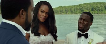 Movie still from “Ride Along 2” (2016), directed by Tim Story – A woman in a white dress standing in front of a body of water; Close Up shot, Over the shoulder angle