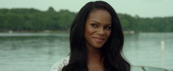 Movie still from “Ride Along 2” (2016), directed by Tim Story – A woman with long black hair smiling for the camera; Close Up shot, Over the shoulder angle