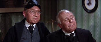 Movie still from “Ride the High Country” (1962), directed by Sam Peckinpah – Two men in suits and hats are looking at the camera; Close Up shot, Low angle