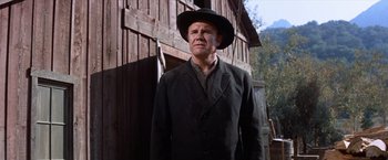 Movie still from “Ride the High Country” (1962), directed by Sam Peckinpah – A man in a black suit and a black cowboy hat; Medium shot, Low angle