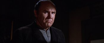 Movie still from “Ride the High Country” (1962), directed by Sam Peckinpah – An older man in a black jacket is looking at the camera; Close Up shot, Low angle