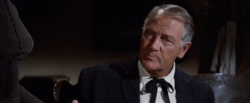 Movie still from “Ride the High Country” (1962), directed by Sam Peckinpah – An older man wearing a suit and tie; Close Up shot, Over the shoulder angle