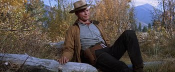Movie still from “Ride the High Country” (1962), directed by Sam Peckinpah – A man sitting on the ground wearing a cowboy hat; Medium shot, Low angle