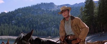 Movie still from “Ride the High Country” (1962), directed by Sam Peckinpah – A man riding a horse in the mountains; Medium shot, Low angle