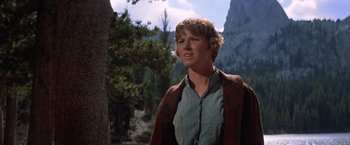 Movie still from “Ride the High Country” (1962), directed by Sam Peckinpah – A woman standing next to a tree in the woods; Medium shot, Low angle