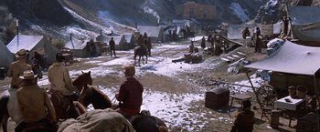 Movie still from “Ride the High Country” (1962), directed by Sam Peckinpah – A group of people riding horses on a snow covered ground; Extreme Wide shot, High angle