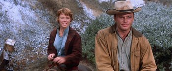 Movie still from “Ride the High Country” (1962), directed by Sam Peckinpah – A man and a woman sitting next to each other on a horse; Medium shot, Low angle