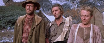 Movie still from “Ride the High Country” (1962), directed by Sam Peckinpah – A group of men standing next to each other in front of a snowy mountain; Medium shot, Low angle