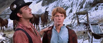 Movie still from “Ride the High Country” (1962), directed by Sam Peckinpah – A man standing next to a woman in front of horses; Close Up shot, Low angle