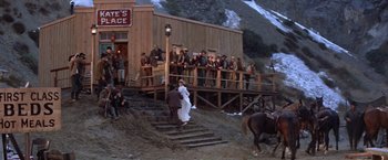 Movie still from “Ride the High Country” (1962), directed by Sam Peckinpah – A man and a woman are walking down the steps; Wide shot, High angle