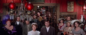 Movie still from “Ride the High Country” (1962), directed by Sam Peckinpah – A group of people standing in front of a lamp post; Medium shot, Low angle