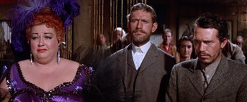 Movie still from “Ride the High Country” (1962), directed by Sam Peckinpah – A man in a suit and tie standing in front of a crowd; Medium shot, Over the shoulder angle