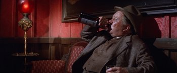 Movie still from “Ride the High Country” (1962), directed by Sam Peckinpah – An older man drinking a glass of wine; Medium shot, High angle