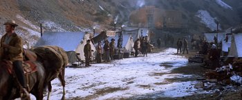 Movie still from “Ride the High Country” (1962), directed by Sam Peckinpah – A group of people standing around tents in the snow; Extreme Wide shot, High angle