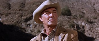 Movie still from “Ride the High Country” (1962), directed by Sam Peckinpah – An older man wearing a cowboy hat in a field; Close Up shot, Low angle