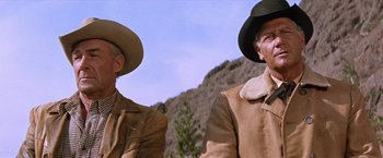 Movie still from “Ride the High Country” (1962), directed by Sam Peckinpah – A couple of men standing next to each other on top of a hill; Medium shot, Low angle