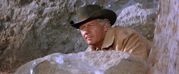 Movie still from “Ride the High Country” (1962), directed by Sam Peckinpah – A man wearing a cowboy hat is leaning against a rock; Close Up shot, Low angle