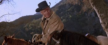 Movie still from “Ride the High Country” (1962), directed by Sam Peckinpah – A man riding on the back of a brown horse; Medium shot, Low angle