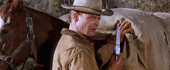 Movie still from “Ride the High Country” (1962), directed by Sam Peckinpah – A man in a cowboy hat holding a gun; Close Up shot, Low angle