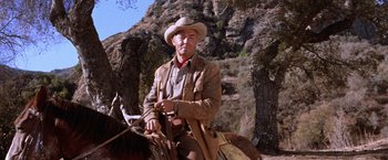 Movie still from “Ride the High Country” (1962), directed by Sam Peckinpah – An older man riding a horse in the mountains; Medium shot, Low angle
