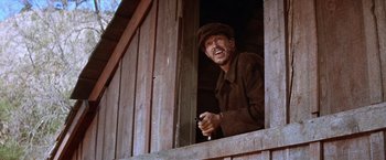 Movie still from “Ride the High Country” (1962), directed by Sam Peckinpah – A man standing in the window of an old barn; Medium shot, Low angle