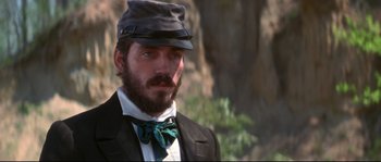 Movie still from “Ride with the Devil” (1999), directed by Ang Lee – A man with a beard wearing a hat and a tie; Close Up shot, Over the shoulder angle