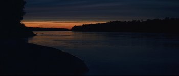 Movie still from “Ride with the Devil” (1999), directed by Ang Lee – A body of water at night with the sun going down; Extreme Wide shot, High angle