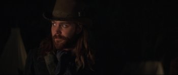 Movie still from “Ride with the Devil” (1999), directed by Ang Lee – A man with long hair wearing a hat and a scarf; Close Up shot, Low angle