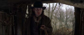 Movie still from “Ride with the Devil” (1999), directed by Ang Lee – A man wearing a hat and holding a basket; Close Up shot, Over the shoulder angle