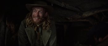 Movie still from “Ride with the Devil” (1999), directed by Ang Lee – A man with long hair wearing a hat and smiling; Close Up shot, Low angle