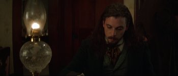 Movie still from “Ride with the Devil” (1999), directed by Ang Lee – A man with long black hair wearing a suit and tie; Close Up shot, High angle