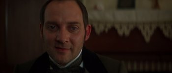 Movie still from “Ride with the Devil” (1999), directed by Ang Lee – A person wearing a suit and bow tie; Close Up shot, Over the shoulder angle
