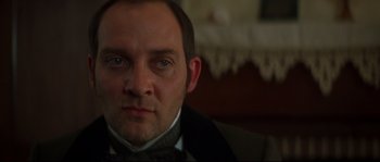 Movie still from “Ride with the Devil” (1999), directed by Ang Lee – A person wearing a suit and tie; Close Up shot, Over the shoulder angle