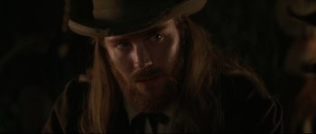 Movie still from “Ride with the Devil” (1999), directed by Ang Lee – A person with long hair and a beard; Close Up shot, Over the shoulder angle