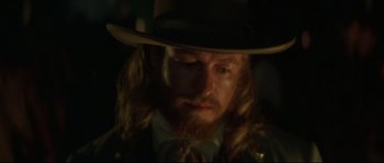 Movie still from “Ride with the Devil” (1999), directed by Ang Lee – A man with long hair and a beard wearing a cowboy hat; Close Up shot, Over the shoulder angle