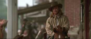 Movie still from “Ride with the Devil” (1999), directed by Ang Lee – A man wearing a cowboy hat sitting on top of a horse; Medium shot, Over the shoulder angle